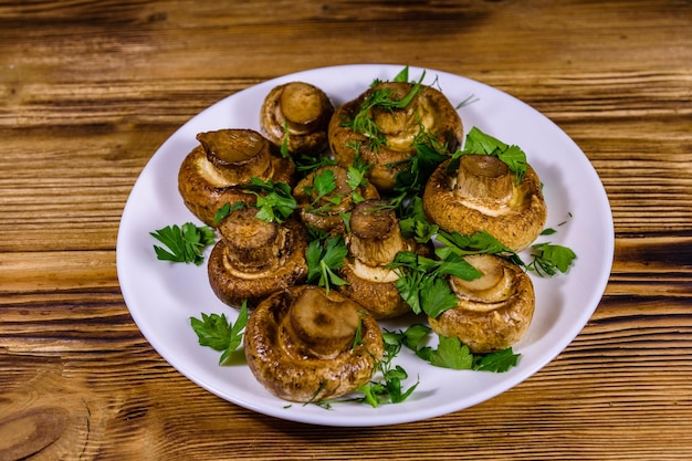 Piatto con aneto e prezzemolo champignon al forno su un tavolo di legno