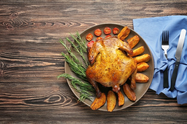 Piatto con birra arrosto può pollo su superficie di legno