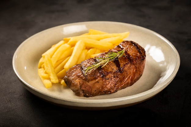 Piatto con bistecca alla griglia e patatine fritte