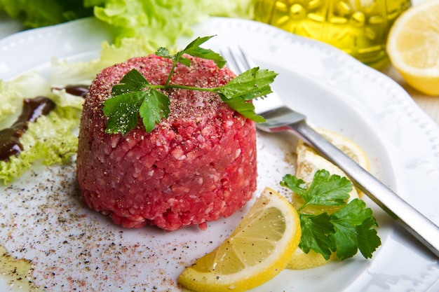 piatto con carne alla tartara e fette di limone