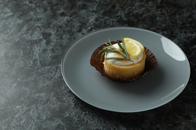 Piatto con cupcake al limone su tavola affumicata nera