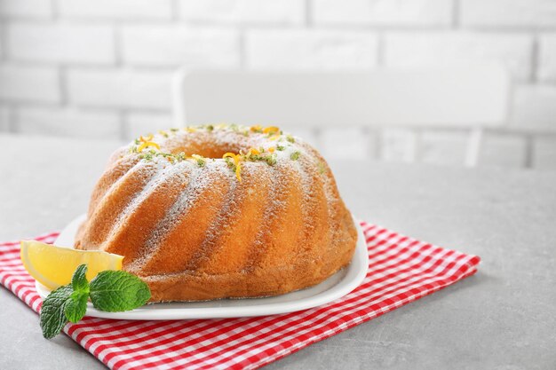 Piatto con deliziosa torta di agrumi e limone sul tavolo