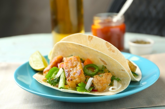Piatto con deliziosi tacos di pesce sul tavolo
