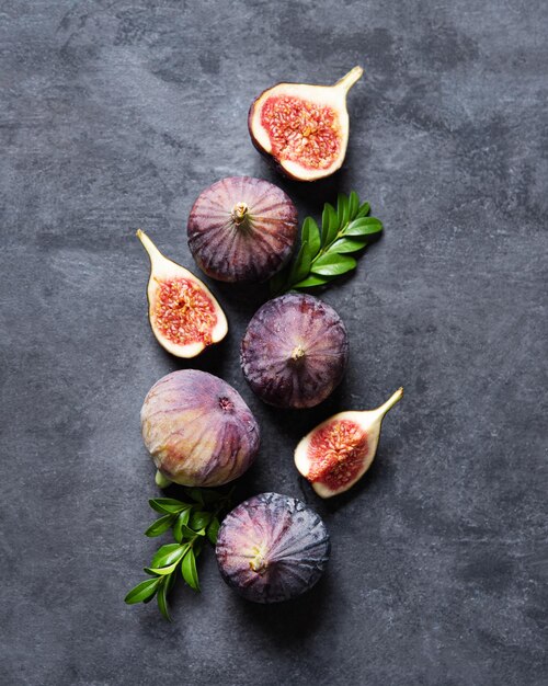 Piatto con fichi freschi maturi su sfondo grigio scuro. Concetto di cibo sano. Copia spazio e vista dall'alto.