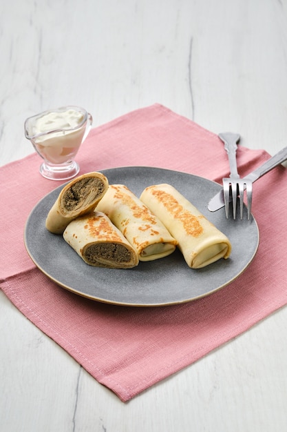 Piatto con frittelle sottili ripiene di carne macinata di coniglio