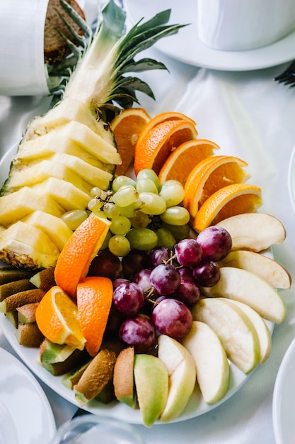 Piatto con frutta Tavolo da dessert decorato per una festa Frutta fresca biologica esotica Spuntini leggeri in un piatto su un tavolo da buffet