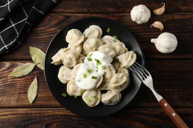 Piatto con gli gnocchi e l'asciugamano su fondo di legno, vista superiore