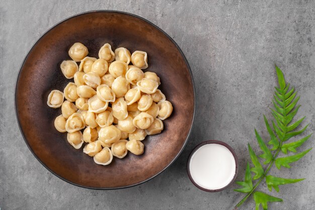 Piatto con gnocchi chiamato pelmeni a base di pasta con ripieno di carne o verdure e bollito