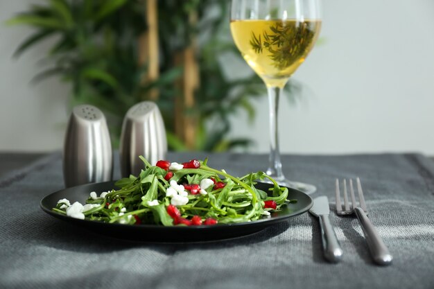 Piatto con gustosa insalata di rucola sul tavolo