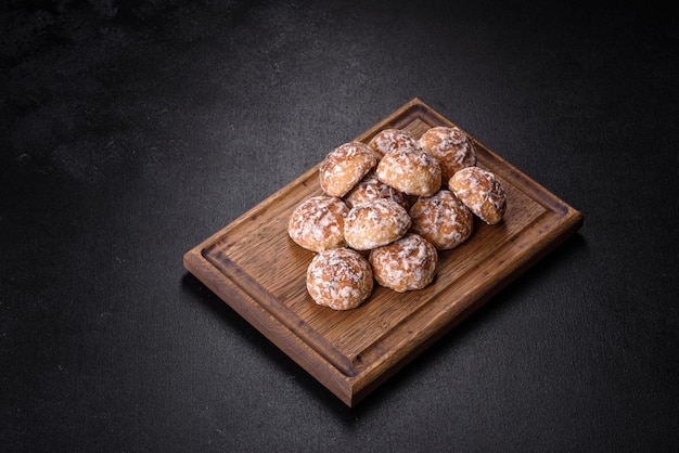 Piatto con gustosi biscotti di pan di zenzero fatti in casa sul tavolo di cemento scuro