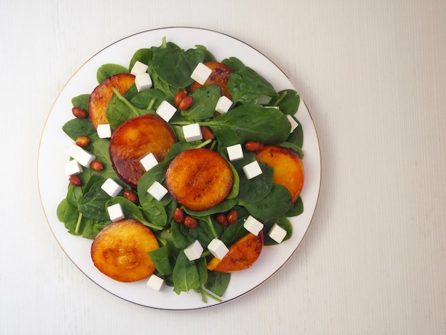 Piatto con insalata di pesche formaggio spinaci