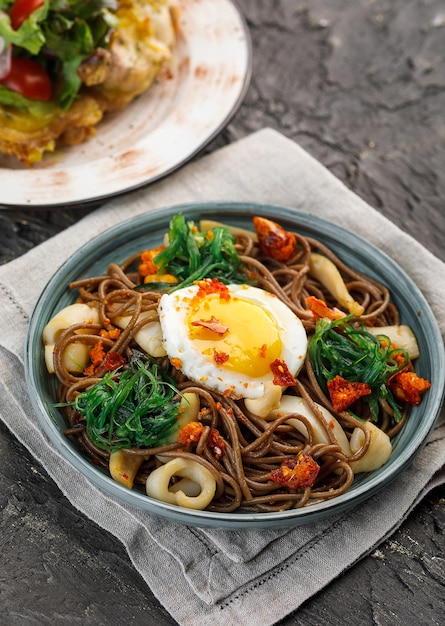 Piatto con noodle al saraceno di cibo asiatico con funghi e verdure all'uovo