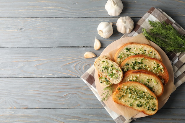 Piatto con pane all'aglio tostato e aneto su fondo di legno, vista superiore