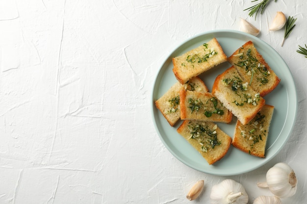 Piatto con pane all'aglio tostato su fondo bianco, vista superiore