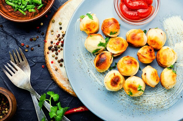 Piatto con pelmeni saporiti arrostiti.Gnocchi fritti.Pelmeni russi o gnocchi di carne