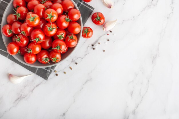 piatto con pomodorini e spezie su fondo di marmo bianco