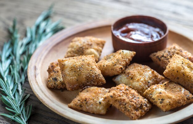 Piatto con ravioli fritti sul bordo di legno