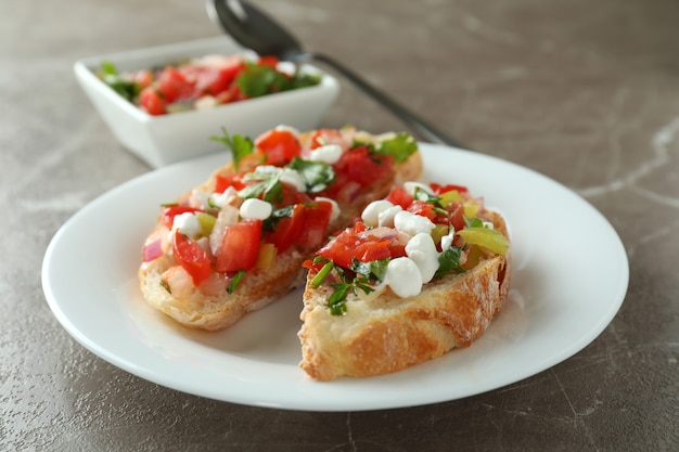 Piatto con snack bruschette su tavolo grigio strutturato