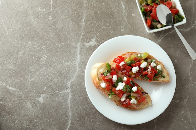 Piatto con snack bruschette su tavolo grigio strutturato