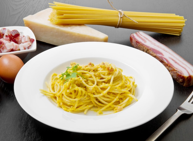 Piatto con spaghetti e ingredienti alla carbonara