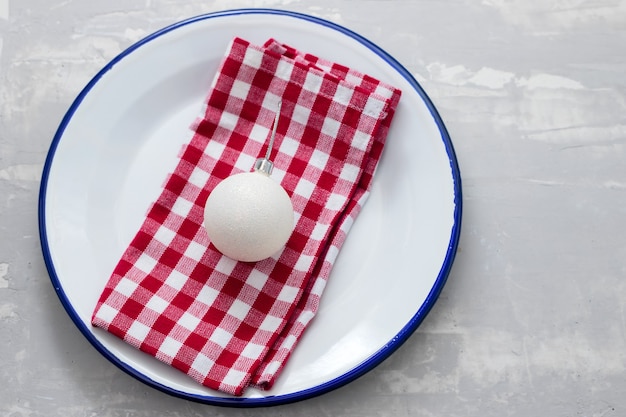 Piatto con tovagliolo e giocattolo di Natale su fondo in ceramica