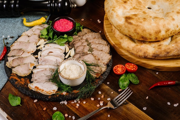 Piatto con varietà su carne affumicata tagliata a fette con erbe aromatiche