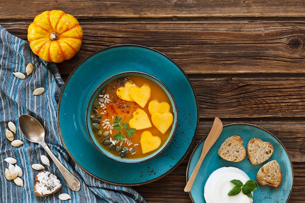 piatto con zuppa di zucca fresca fatta in casa con semi e toast a forma di cuore