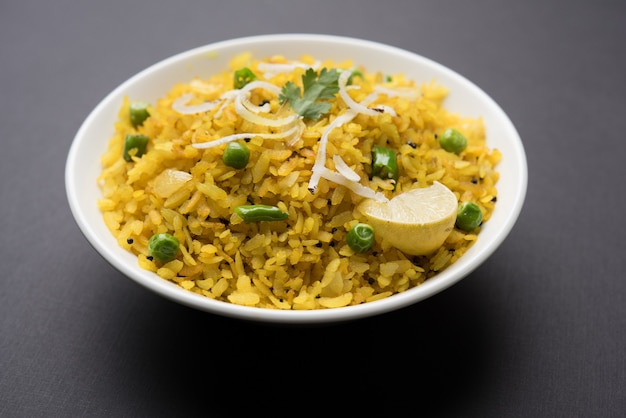 Piatto da colazione indiano Poha Conosciuto anche come Pohe o Aalu poha composto da riso battuto o riso appiattito. I fiocchi di riso sono leggermente fritti in olio con spezie serviti con tè caldo