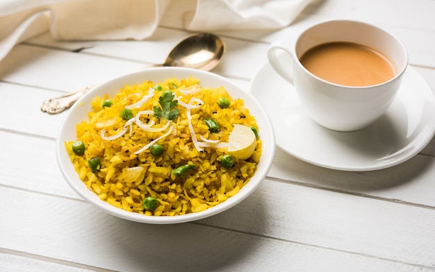 Piatto da colazione indiano Poha Conosciuto anche come Pohe o Aalu poha composto da riso battuto o riso appiattito. I fiocchi di riso sono leggermente fritti in olio con spezie serviti con tè caldo