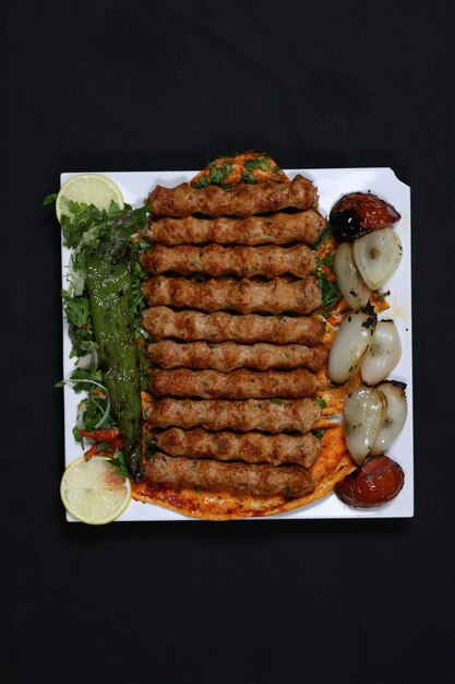 Piatto da portata per kebab di manzo allo spiedo con fette di peperone cipolla pomodoro grigliato Griglie per barbecue Mashawi