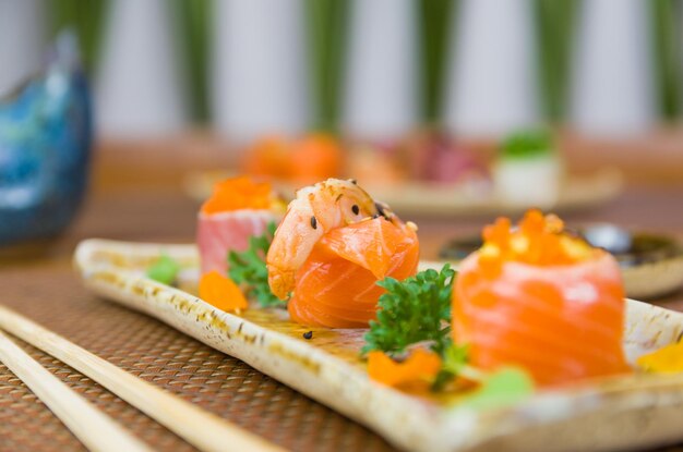 Piatto decorato con diversi gusti di sushi elegante Messa a fuoco selettiva