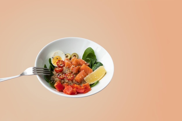 Piatto della ciotola con il limone degli spinaci della quinoa del salmone fresco del piatto del poke per uno spazio della copia di dieta sana