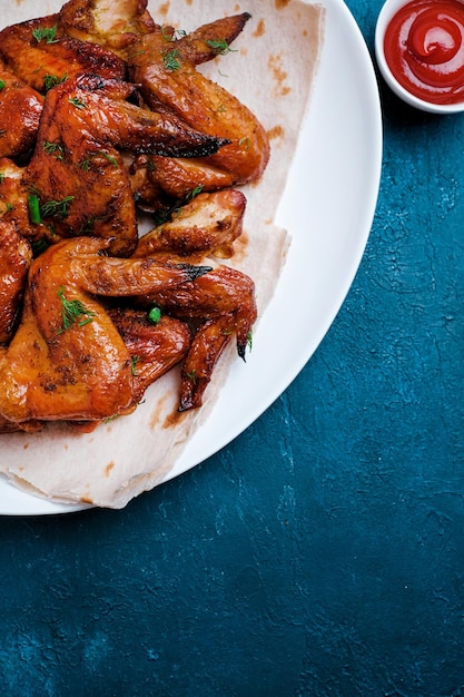 Piatto di ali di pollo barbecue su sfondo blu Vista dall'alto Spazio di copia