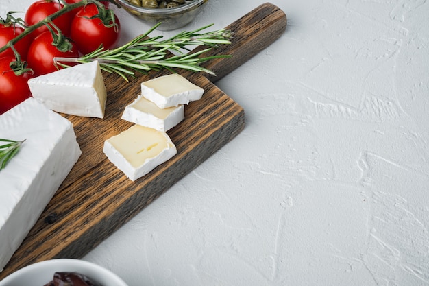 Piatto di antipasti con formaggio fresco, pane e olive, su bianco