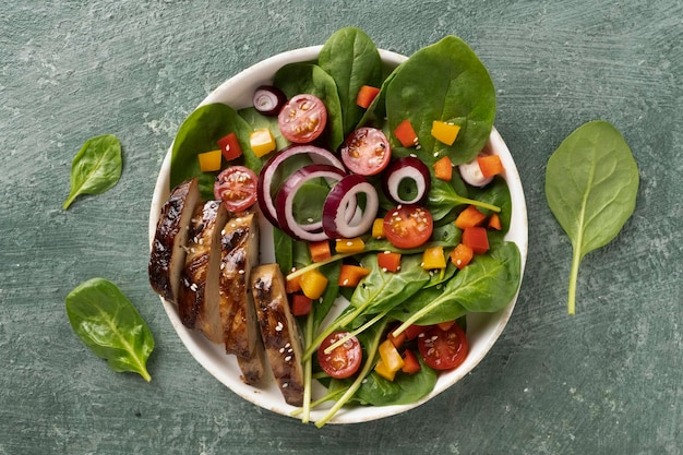 Piatto di carne alla griglia con insalata di spinaci