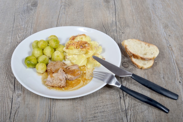 Piatto di carne con patate gratinate e cavoletti di Bruxelles