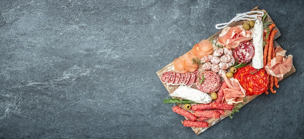 Piatto di carne italiano prosciutto prosciutto salame aperitivo party concept Formato banner lungo vista dall'alto