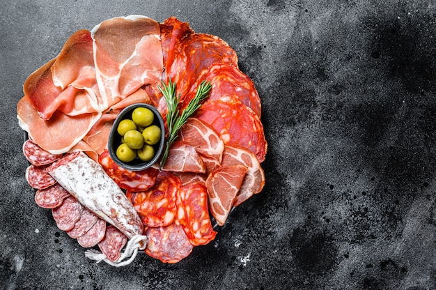 Piatto di carne stagionato di tapas spagnole tradizionali. Chorizo, jamon serrano, lomo e fuet. Vista dall'alto.