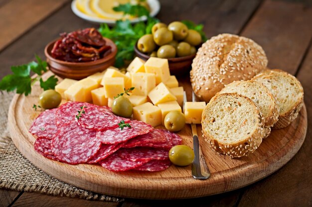 Piatto di catering antipasto con salami e formaggio su uno sfondo di legno