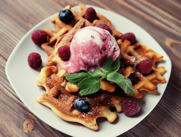 Piatto di cialde belghe con gelato e frutti di bosco freschi lamponi e mirtilli