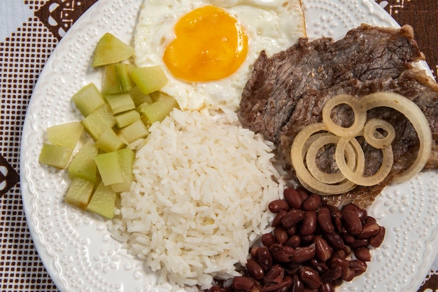 Piatto di cibo brasiliano visto dall'alto con due proteine