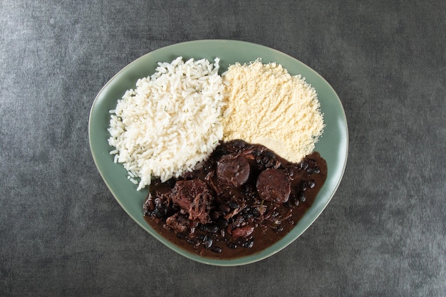 Piatto di cibo tradizionale brasiliano Feijoada Sfondo grigio