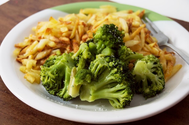 Piatto di cibo verde e giallo con patatine fritte e broccoli