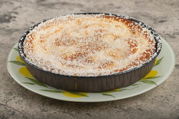 Piatto di deliziosa torta con granelli di cocco sulla superficie della pietra