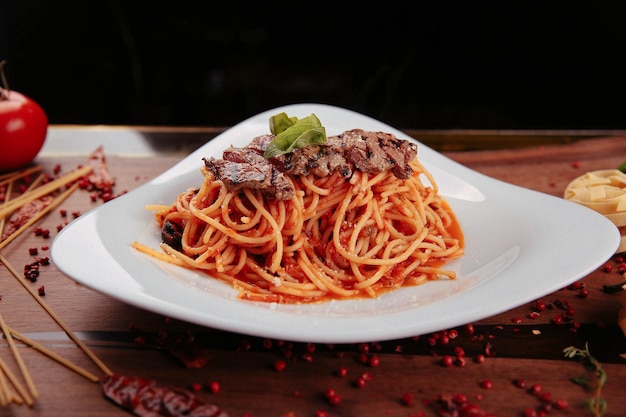 Piatto di deliziosi spaghetti alla bolognese o alla bolognese con salsa di pomodoro guarnita con formaggio