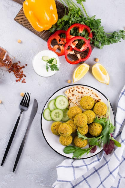 Piatto di falafel al forno con pane pita, salsa e foglie di insalata