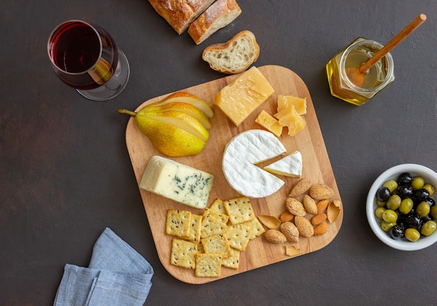 Piatto di formaggi con cracker, mandorle e uva