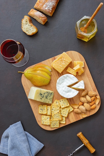 Piatto di formaggi con cracker, mandorle e uva