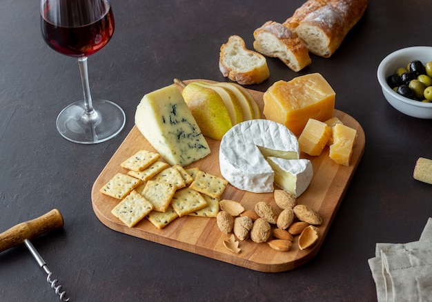 Piatto di formaggi con cracker, mandorle e uva