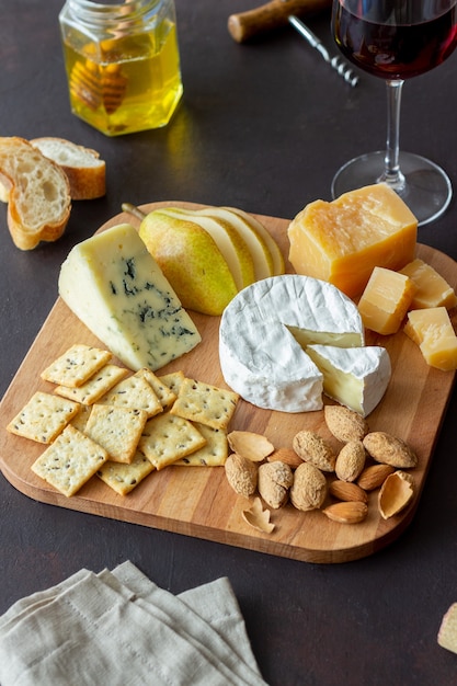 Piatto di formaggi con cracker, mandorle e uva